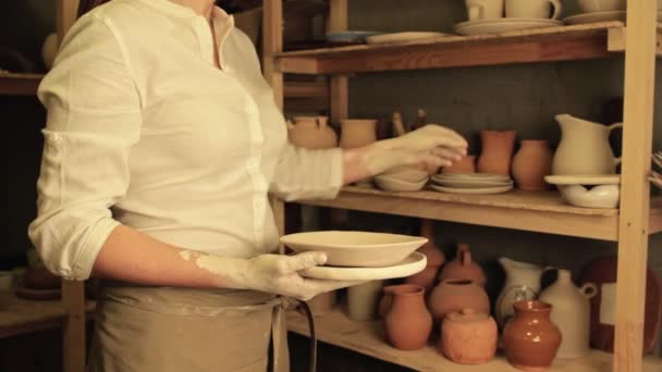 Pottery shop artist handmade clay plates stack — Stock Video