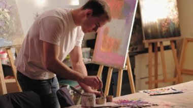 Akrilik boya karıştıran profesyonel sanat yeteneği olan adam.