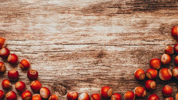 Brown wooden background organic snacks hazelnut — Stockfoto