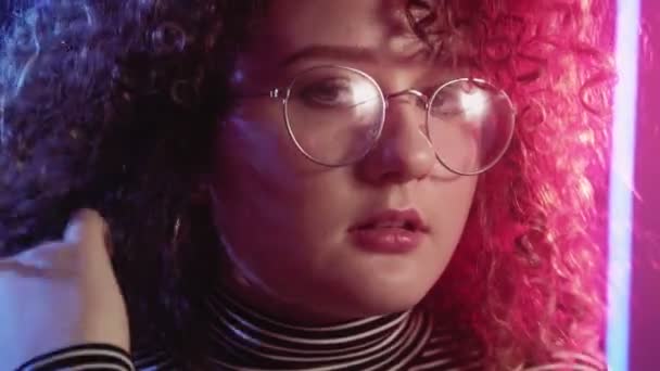 Неонова дівчина портрет жінка грає кучеряве волосся рожевий — стокове відео
