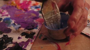 art school male hand mixing paint palette brush