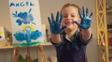 Çocuklar sanat okulunda mutlu kız avuç içleri mavi boya