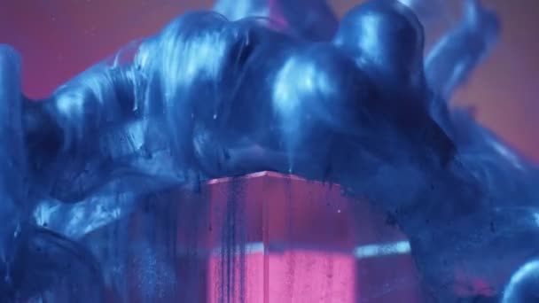 Boya mavi parıltılı sıvı pembe piramit suyu sıçratır — Stok video