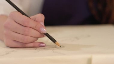 Kalem bezi çizen kadın eli çiziyor.