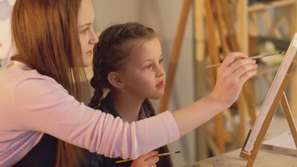 Young artist mother daughter painting together — 图库视频影像