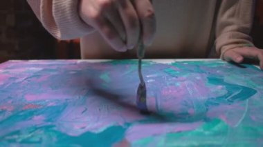 Sanat hobisi yetenekli kadın tuval spatulasını boyuyor.