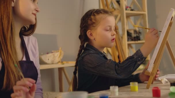 Arte lección niñera enseñanza chica pintura gouache — Vídeo de stock