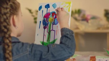Genç ressam, hobi kızı soyutlaması çiziyor.