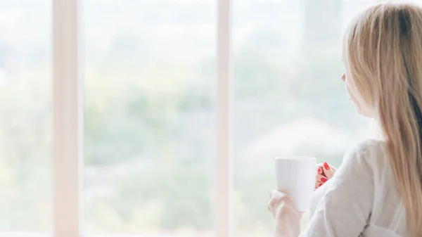 Morgon kaffe pensiv kvinna fönster mugg varm dryck — Stockfoto