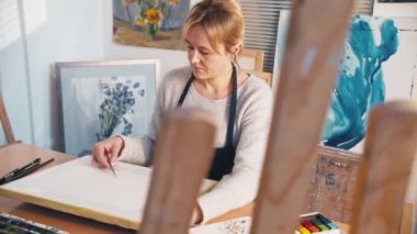 yaratıcı atölye son sınıf öğrencisi kadın tuval çiziyor.