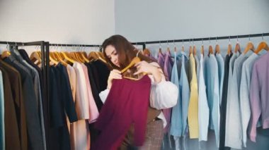 Giysi seçen alışveriş düşkünü bir kadın.