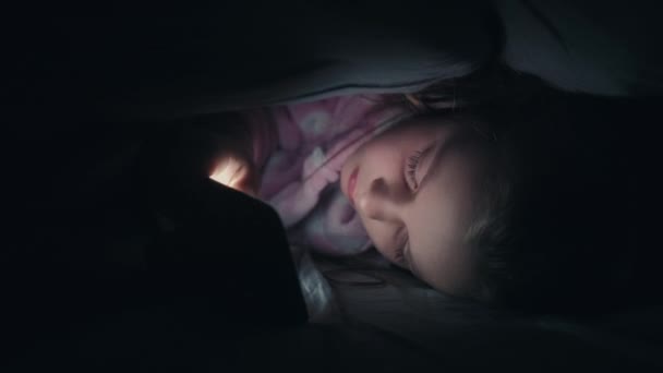 Gyermek álmatlan éjszaka lány használ telefon takaró — Stock videók