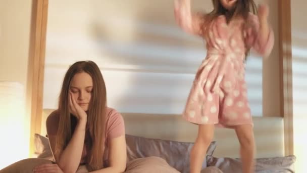 Criança disciplina mãe cansado filha dançando cama — Vídeo de Stock