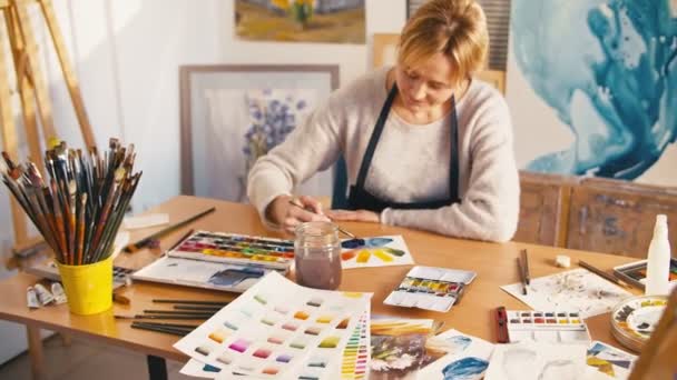 Kunstenaar galerie senior vrouw schilderen kleurenwiel — Stockvideo