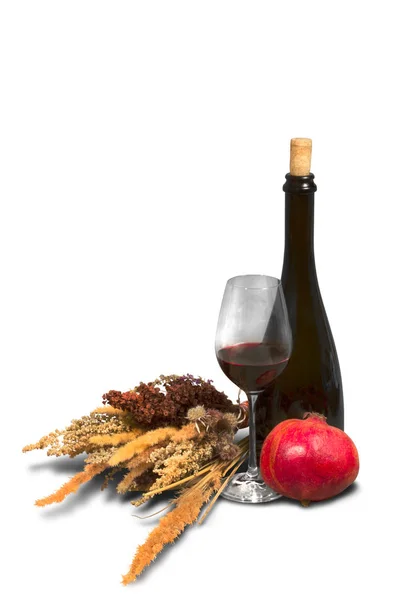 Куча полевых сорняков с бутылкой, бокалом вина и гранатом — стоковое фото