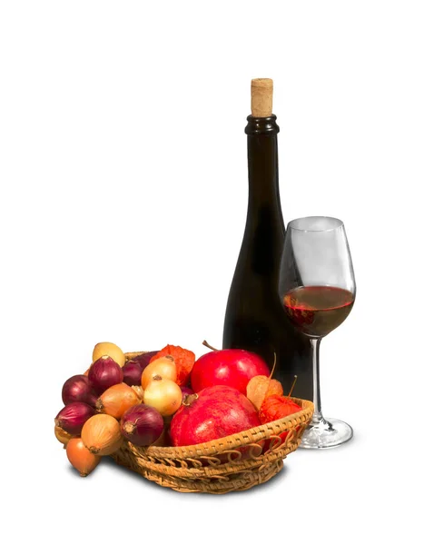 Zwarte fles met glas wijn en rieten mand van vruchten — Stockfoto