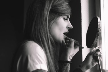 Dövmeli kadın aynanın önünde yapmak yapıyor