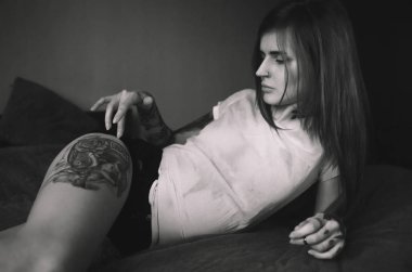 Yatakta yatan genç dövmeli kadın