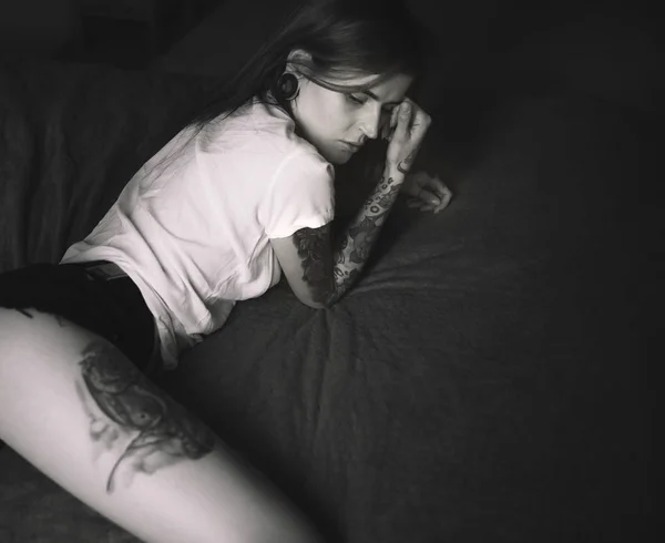 Jovem mulher tatuada deitada na cama — Fotografia de Stock