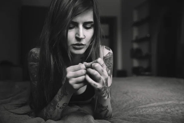 Молодая татуированная женщина с длинными волосами лежит на кровати , — стоковое фото