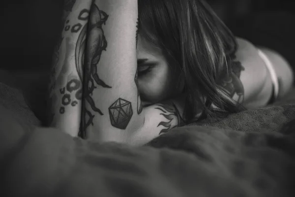 Молодая татуированная женщина закрывает лицо — стоковое фото