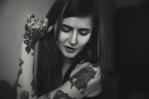 Молодая татуированная женщина с длинными волосами позирует Стоковое Изображение