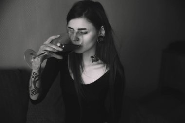 Yatak odasında şarap içme uzun saçlı genç dövmeli kadın