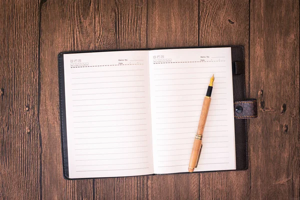 Una mesa de madera con un cuaderno, sobres y otros artículos de papelería . —  Fotos de Stock