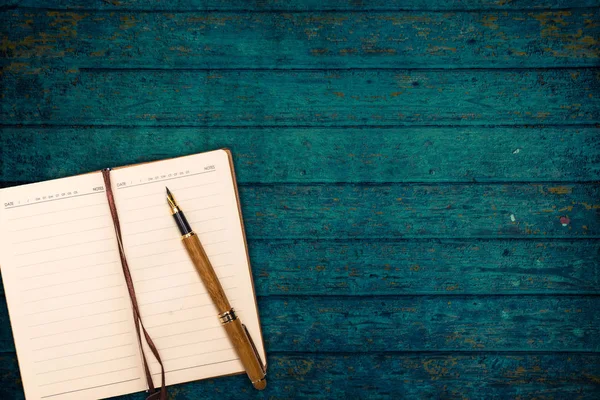 Ovanifrån, anteckningsbok och papper med penna — Stockfoto