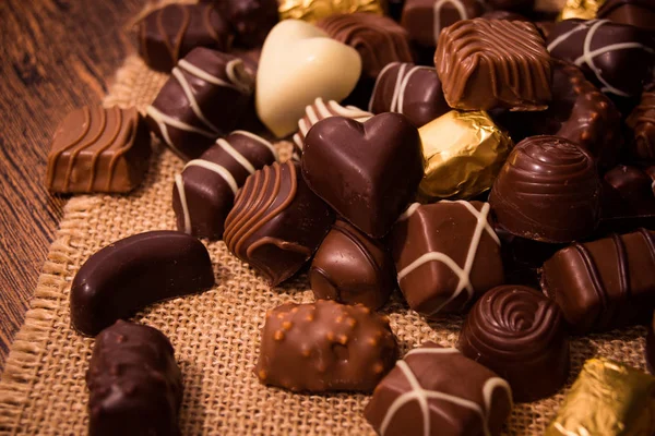 Chocolates variados em fundo de madeira — Fotografia de Stock