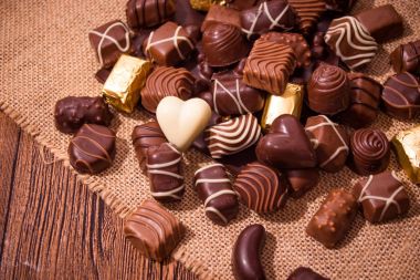 Ahşap arka plan üzerinde çeşitli çikolatalar