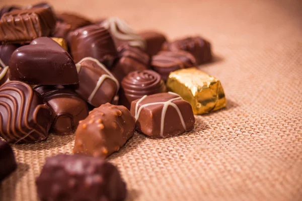 Ahşap arka plan üzerinde çeşitli çikolatalar