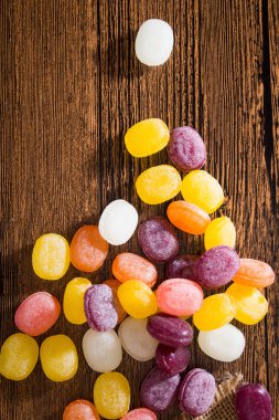 Ahşap arka plan üzerinde renkli meyve şeker