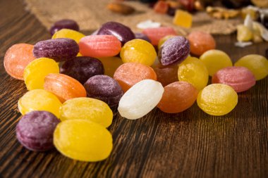 Ahşap arka plan üzerinde renkli meyve şeker