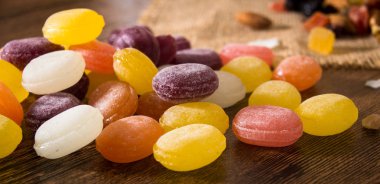 Ahşap arka plan üzerinde renkli meyve şeker