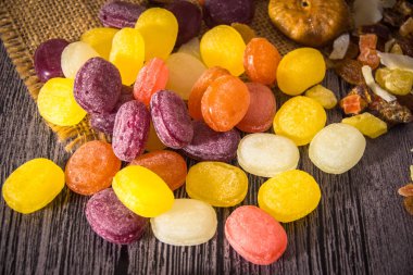 Ahşap arka plan üzerinde renkli meyve şeker