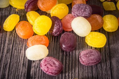 Ahşap arka plan üzerinde renkli meyve şeker