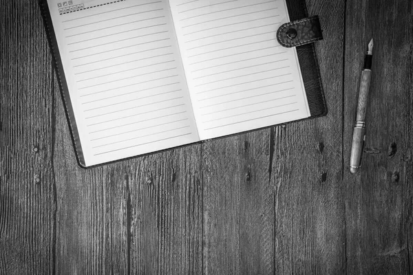 Μαύρο και άσπρο. Το Top view. Σημειωματάριο ένα τραπέζι από ξύλο. — Φωτογραφία Αρχείου