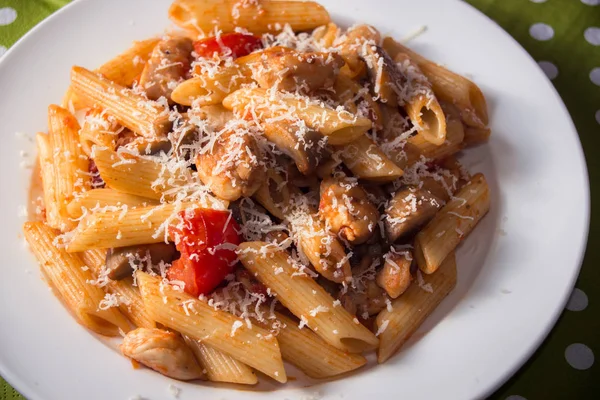 Pasta di penne con funghi, pollo, pomodori e formaggio parmesa — Foto Stock