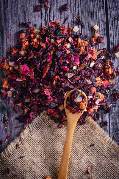 Mix tea with dried fruits and dried flowers and wooden spoon
