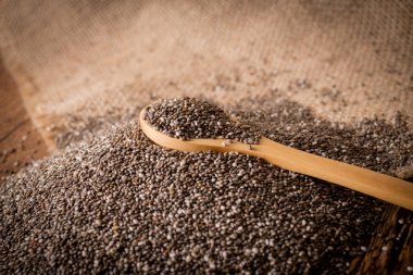 Chia tohum ve tahta kaşık ahşap arka plan üzerinde