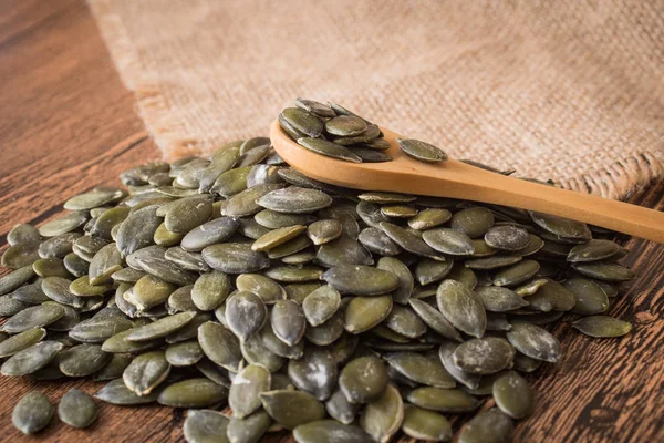 Pumpkin seeds on rustic background — Stock Photo, Image