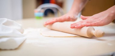 Anne ve kızı el hamur yoğurma masada.