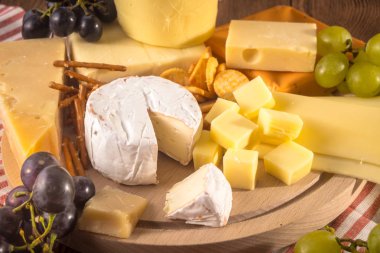 Üzerinde çeşitli peynirler ahşap tahta plaka yuvarlak. Camembert peyniri, 