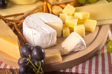 Üzerinde çeşitli peynirler ahşap tahta plaka yuvarlak. Camembert peyniri, 