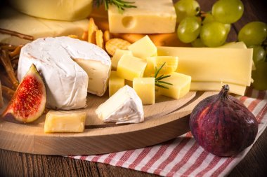 Üzerinde çeşitli peynirler ahşap tahta plaka yuvarlak. Camembert peyniri, 