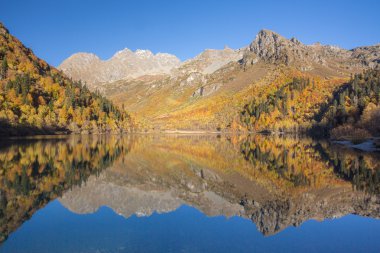Rusya. Caucasus. Sonbahar. Dağlar göle yansıtılır.