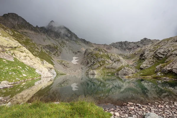 Rússia, Cáucaso, lago de olhos azuis. No dia nublado da rocha refletem-se na água do pequeno lago . — Fotografia de Stock