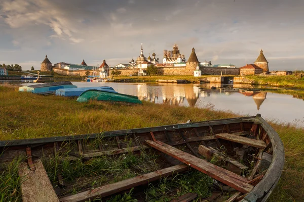 Rusya, Arkhangelsk region, ada Solovki. İyi akşamlar. Eski ahşap tekne karaya ve bir arka plan üzerinde Solovetsky Manastırı. — Stok fotoğraf