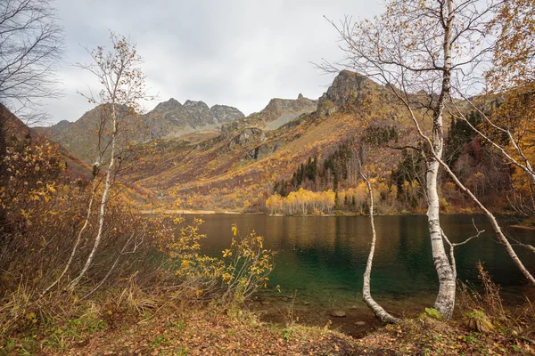 Rusia, Cáucaso. Vista del lago de montaña, árboles y montañas en el otoño . — Foto de Stock